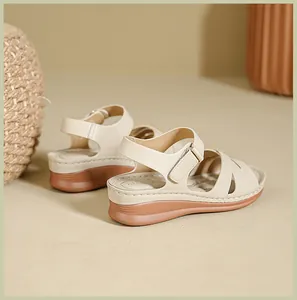 Detailed side view of women's beige wedge sandals featuring adjustable velcro straps