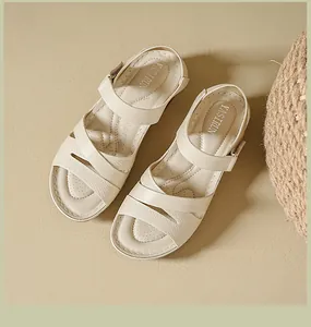 Detailed view of beige wedge sandals with Velcro straps and textured bands