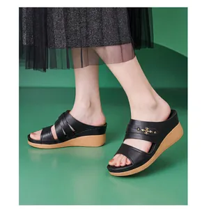 Detail view of stylish black leather wedge sandals with decorative metal hardware for women.