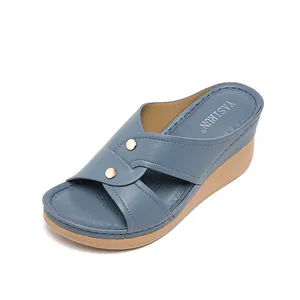 Women's blue wedge slide sandals with decorative studs and cross straps