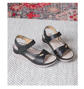 Detail view of stylish black women's wedge sandals with neat stitching and adjustable straps.
