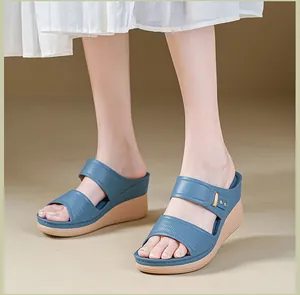 Gros plan de sandales à talons compensés bleues avec brides texturées et bout ouvert.