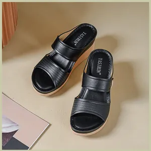 Vue détaillée de sandales compensées noires pour femmes avec brides et logo YASIRUN.