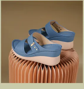 Vue détaillée de sandales compensées bleues à bout ouvert et boucle dorée sur socle plissé.