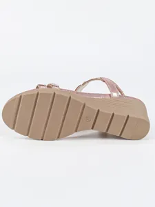 Detailed view of the non-slip ribbed sole of a pink glitter bohemian wedge sandal.