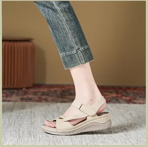 Side view of women's beige wedge sandals with cross-stitch detail and strap