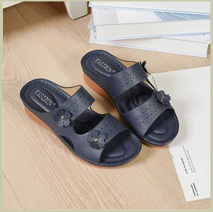Marineblaue Keilsandaletten mit Blumenakzenten und Peep-Toe-Design auf Holzboden