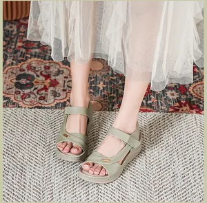 Detailed view of olive green wedge sandals for women with elegant cross-strap design.