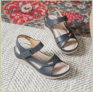 Detail shot of women's navy wedge sandals with white stitching and gold buckle