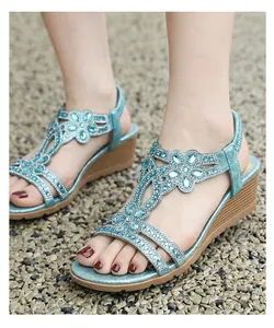 Detail view of blue Bohemian wedge sandals with sparkling rhinestone flowers