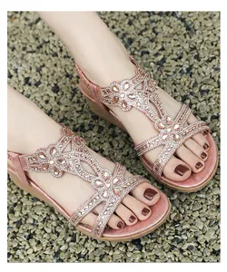 Close-up of bohemian rose gold wedge sandals with intricate rhinestone floral patterns