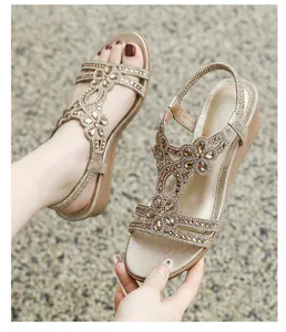 Close-up view of elegant champagne wedge sandals decorated with sparkling rhinestone flower motifs