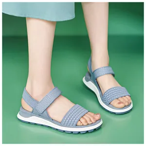 Detailed view of women's breathable blue fly-knit sports sandals with soft white TPR soles