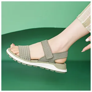 Close-up view of green fly-knit sports sandals on foot with white breathable soft sole detail.