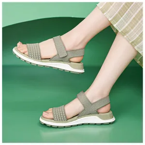 Close-up of comfortable sage green flying knit sports sandals on a female model.