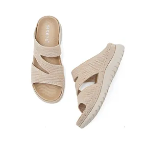 Detailed view of beige knitted hollow upper and thick textured sole of casual slides