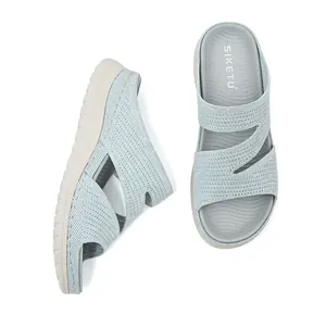 Detailed view of the breathable knitted upper and thick cushioned sole of sport sandals.