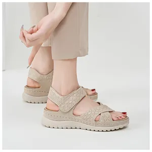 Detailed view of beige mesh platform sports sandals featuring adjustable velcro straps on model.