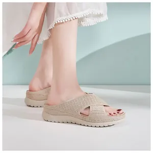 Detailed shot of beige fly-woven cross-strap sandals with comfortable platform sole.