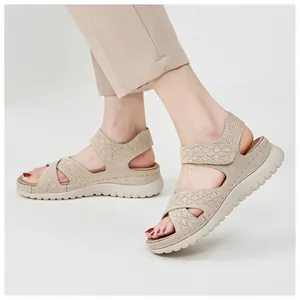 Detail view of women's beige knit sports sandals with velcro straps and thick soles.