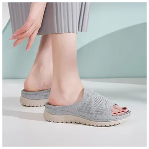 Vista lateral de las sandalias de plataforma de punto gris para mujer con suela de cuña