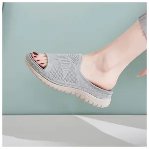 Detalle de sandalia de plataforma de malla tejida gris para mujer con suela beige