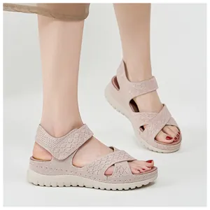 Detailed close-up of pink mesh platform sandals worn by a model in a studio setting