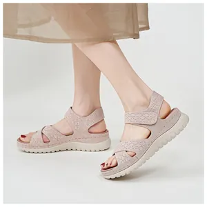 Close-up of pink breathable mesh sandals with thick soles on a model's feet.