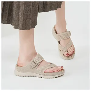 Close-up detail of beige platform sports sandals with mesh texture and velcro strap
