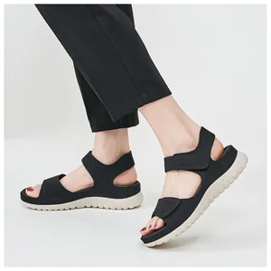 Side view of black sports sandals with thick white soles worn by a model