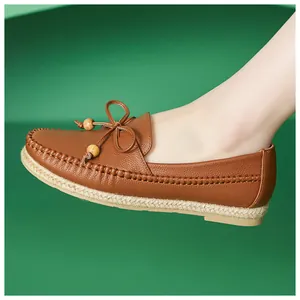Close-up of comfortable brown leather moccasins with bow and wooden beads detail.