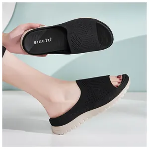 Primer plano de sandalias de punto negras con suelas gruesas para mujer