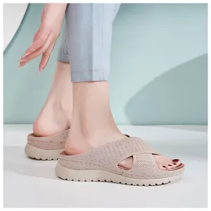 Side view of women's beige breathable knitted leisure platform slides on feet.