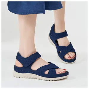 Detail shot of navy blue women's casual sandals with thick beige soles and velcro straps