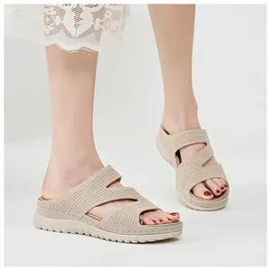 Detailed view of beige knitted wedge sandals featuring stylish cut-outs on feet.