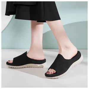 Sandalias negras de malla transpirable con suela gruesa beige en los pies modelo
