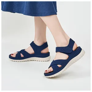 Close-up of navy blue platform sports sandals with velcro strap shown on model's feet