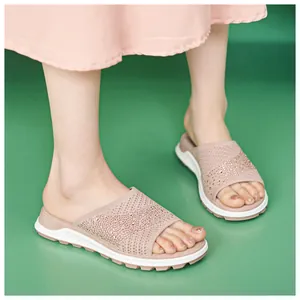 Detailed view of pink fly-knit flat slides featuring sparkling rhinestone embellishments
