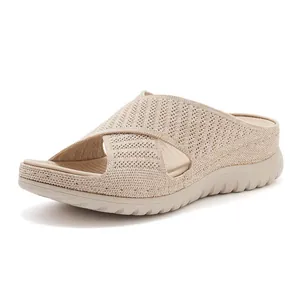 Detailed view of beige fly-knit wedge slide sandals with comfortable cross-strap design