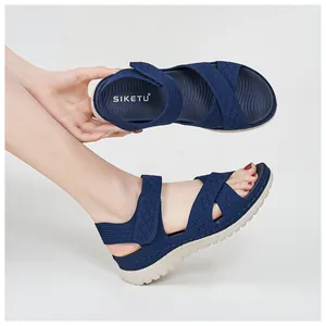 Close-up of navy blue women's platform sandals with knit cross straps and velcro.