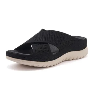 Detail of black flyknit slide sandal with thick sole and cross-strap design for women.