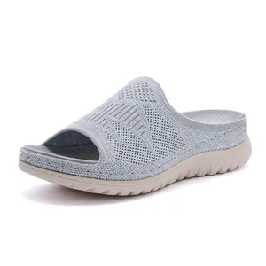 Detalle lateral de sandalias de plataforma en punto gris transpirable para mujer