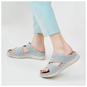 Side view of light grey knitted platform slide sandals for women worn with jeans
