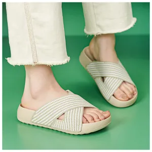 Close-up of beige platform slide sandals with striped knit cross straps and soft sole