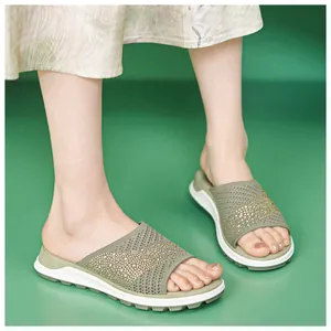 Detailed view of women's olive green fly-knit slide sandals with rhinestone accents.