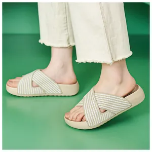 Close-up of stylish thick-sole cross-strap slides with woven stripe texture on feet