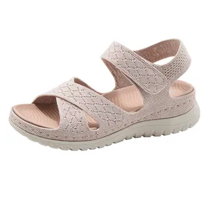 Side profile of women's pink knitted wedge sandals with adjustable velcro strap.