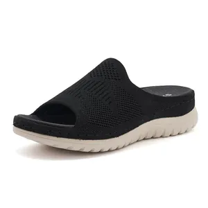 Vista lateral detallada de sandalias de punto negras para mujer con suelas blancas gruesas y cómodas