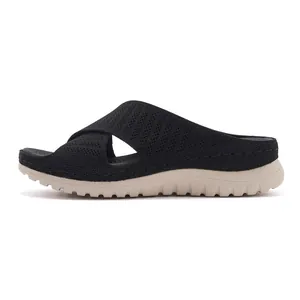 Side view of black fly-knit athletic slide sandals with thick beige platform sole