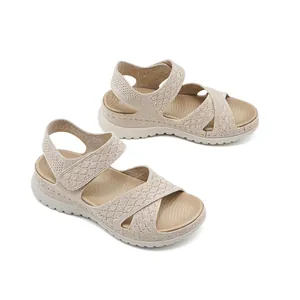 Detailed view of beige platform sports sandals with mesh pattern and velcro strap.